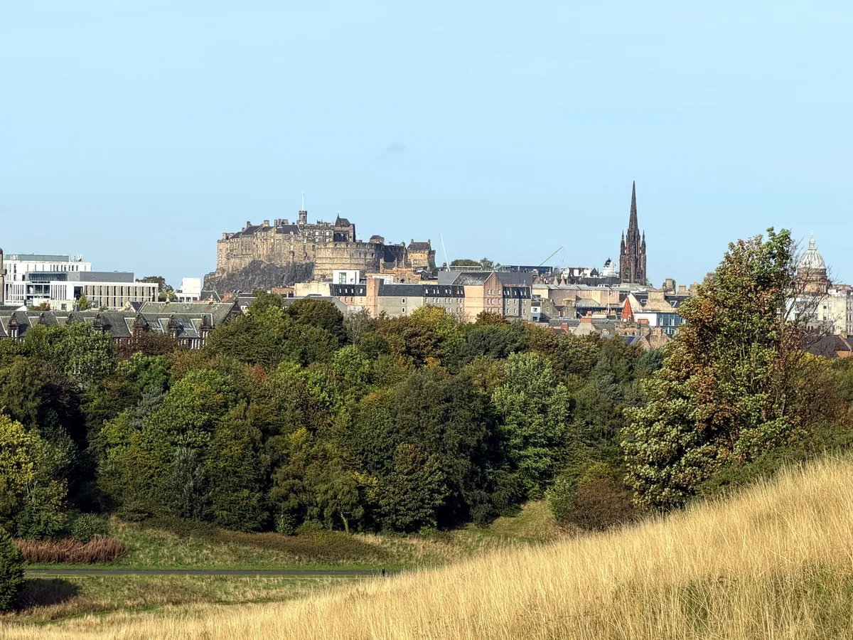 Edinburgh Castle and the Old Town seen across parkland and trees
